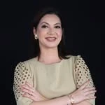 Retrato da Dra. Cíntia Urquiza, de blusa nude e braços cruzados